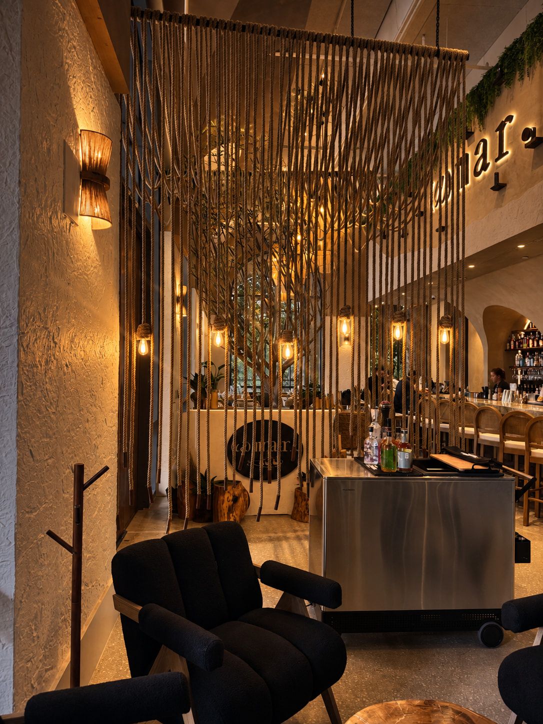 The entrance, with the bar cart and the bar beyond a rope screen